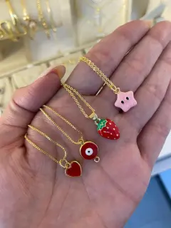 Collares con dijes de corazón, ojitos, fresa y estrella (rosada). Al mayor